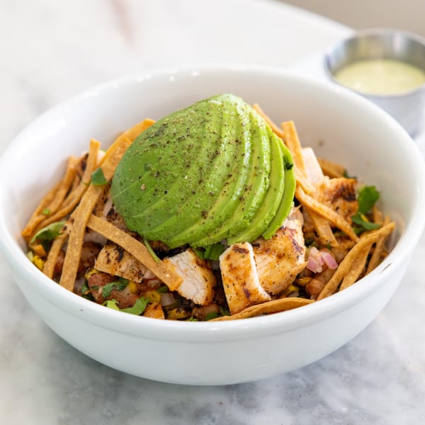 Float Restaurant's chicken bowl with avocado, tortilla strips, and a side of dressing.