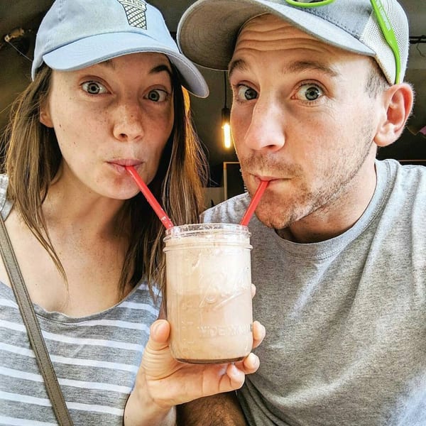 A couple with wide eyes shares a milkshake with two red straws at Float Restaurant.