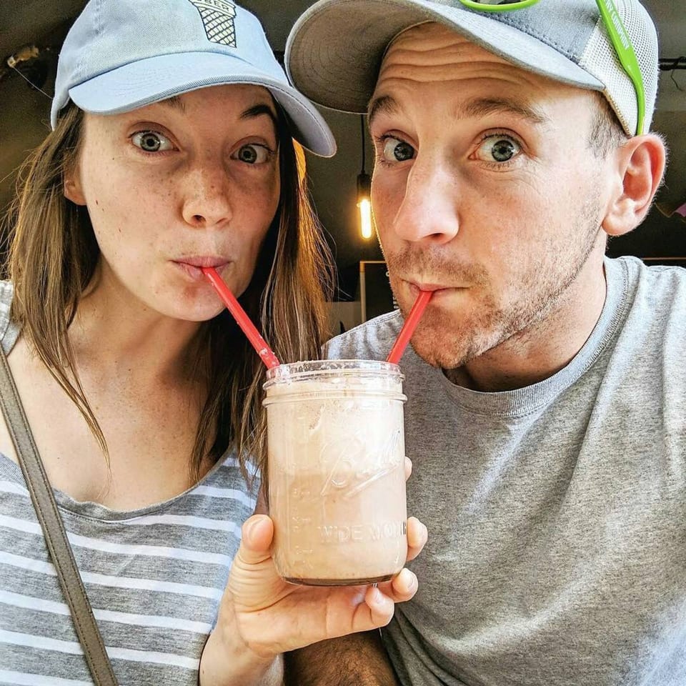 A couple with wide eyes shares a milkshake with two red straws at Float Restaurant.