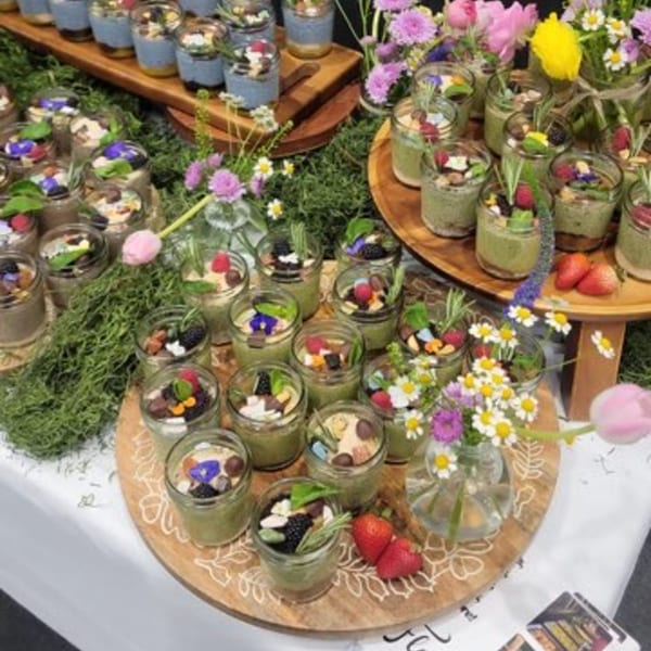 Assortment of Float Restaurant's parfaits in jars, garnished with berries, nuts, and edible flowers.